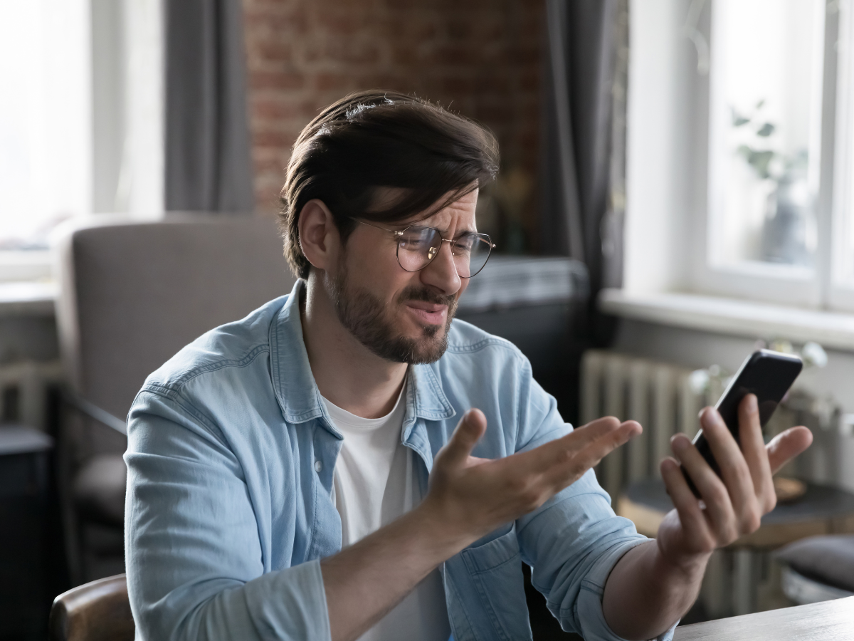 A man is struggling to click on a website using his phone